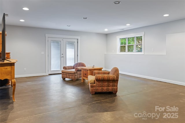 living area with baseboards, recessed lighting, and finished concrete floors