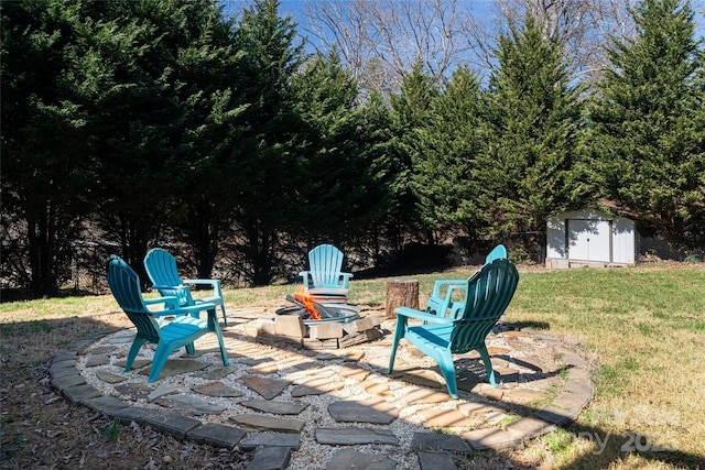 view of patio featuring an outbuilding, an outdoor fire pit, and a shed