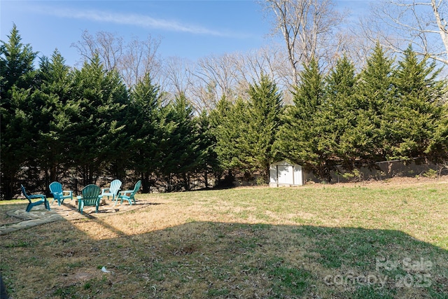 view of yard featuring an outbuilding, a storage unit, and fence