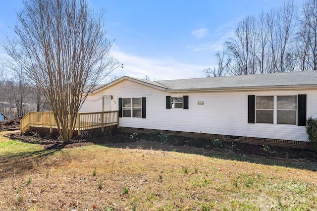 view of side of home featuring crawl space, a yard, and a wooden deck