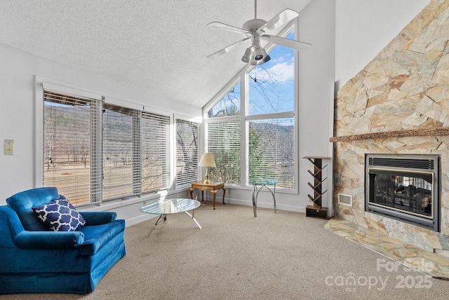 sunroom / solarium featuring ceiling fan, a fireplace, visible vents, and vaulted ceiling