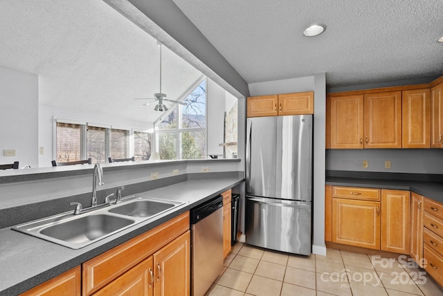 kitchen featuring ceiling fan, light tile patterned flooring, a sink, appliances with stainless steel finishes, and dark countertops