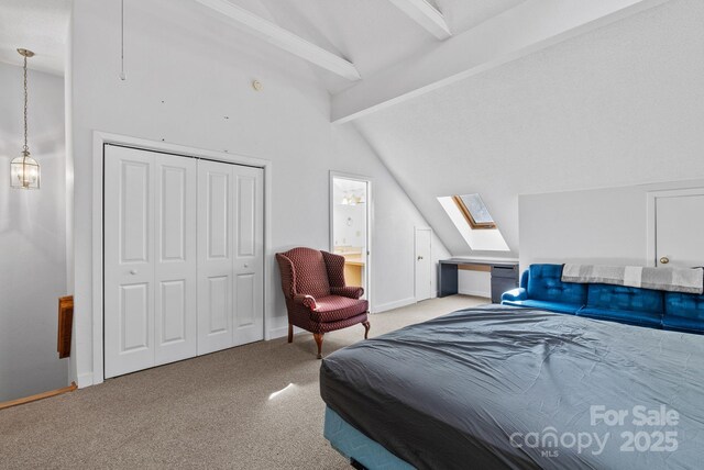 bedroom featuring lofted ceiling with skylight, a closet, baseboards, and carpet flooring