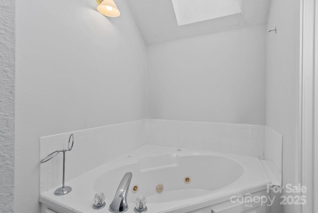 bathroom with a whirlpool tub and a textured ceiling