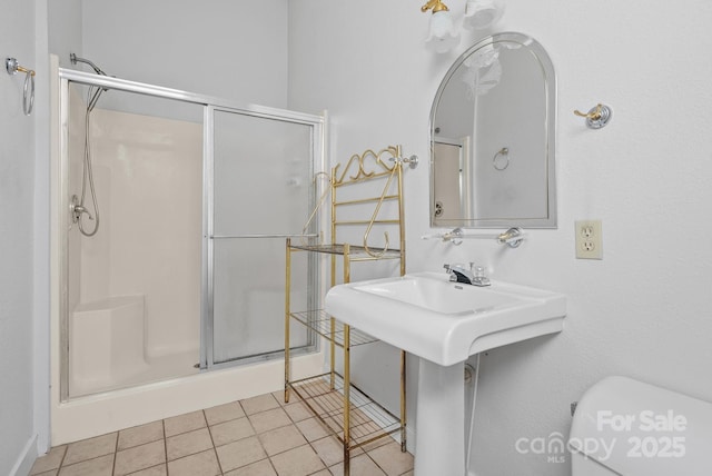 full bathroom featuring a shower stall, toilet, and tile patterned floors