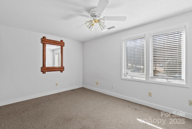 unfurnished room featuring a textured ceiling, ceiling fan, carpet floors, visible vents, and baseboards