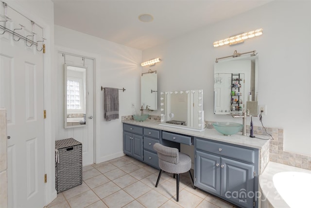 bathroom featuring tile patterned flooring, a sink, a bathing tub, and double vanity