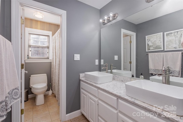 full bathroom featuring double vanity, tile patterned flooring, and a sink