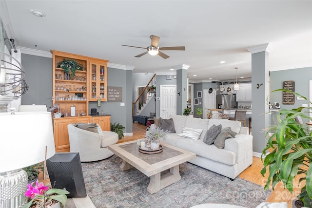 living room with ornamental molding, recessed lighting, light wood-style flooring, and stairway