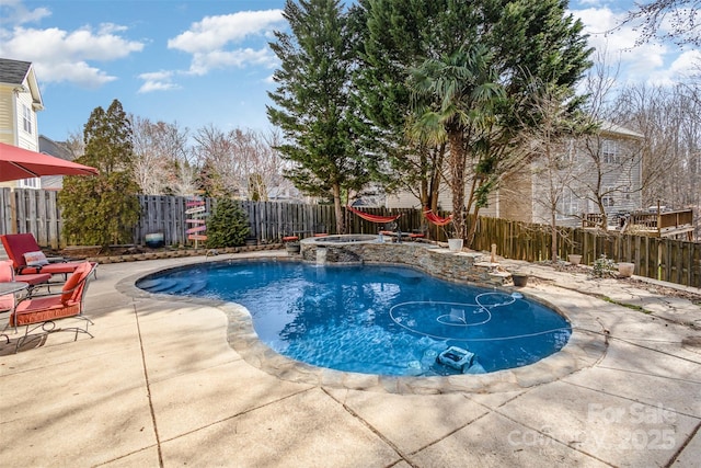 view of swimming pool with a fenced backyard, a pool with connected hot tub, and a patio