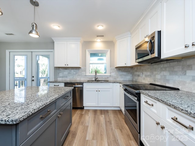 kitchen featuring visible vents, appliances with stainless steel finishes, white cabinetry, and a sink