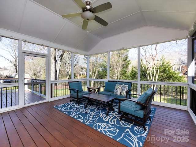 sunroom / solarium featuring a wealth of natural light, ceiling fan, and vaulted ceiling