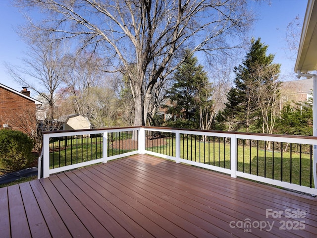 wooden terrace with an outdoor structure and a yard