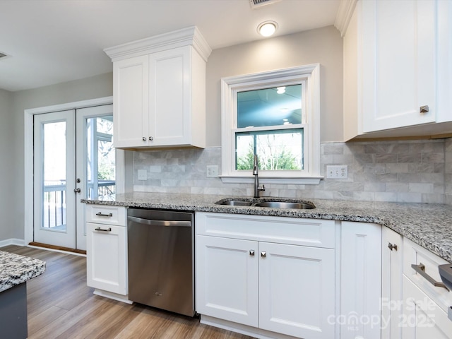 kitchen with a sink, light wood-type flooring, dishwasher, and white cabinets