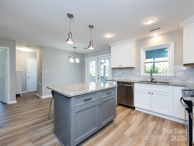 kitchen featuring visible vents, white cabinets, appliances with stainless steel finishes, and a sink