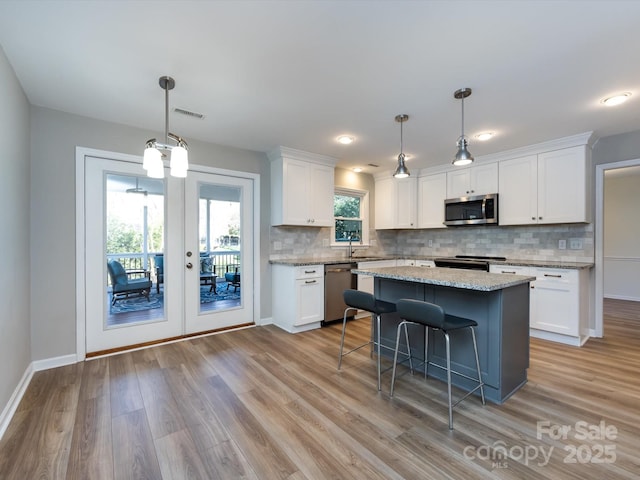 kitchen featuring appliances with stainless steel finishes, white cabinetry, and a sink