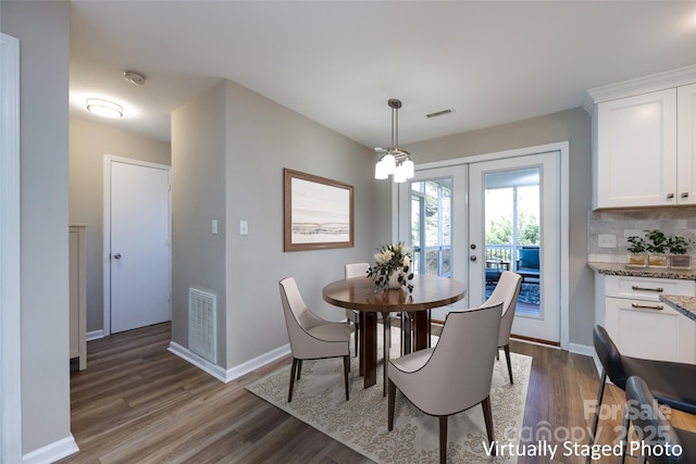 dining room with wood finished floors, visible vents, and baseboards