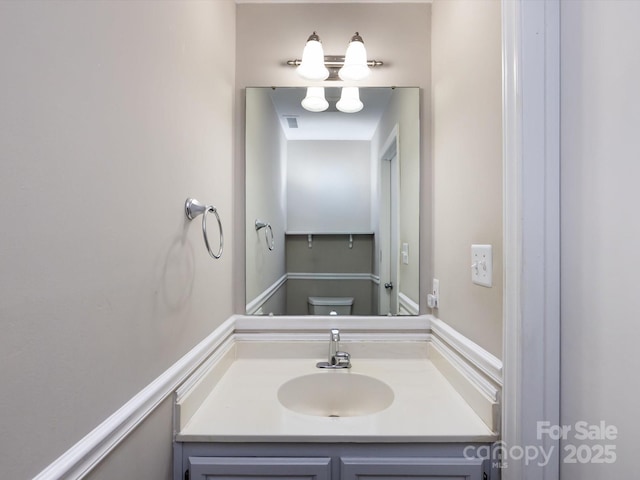 bathroom featuring visible vents, toilet, and vanity