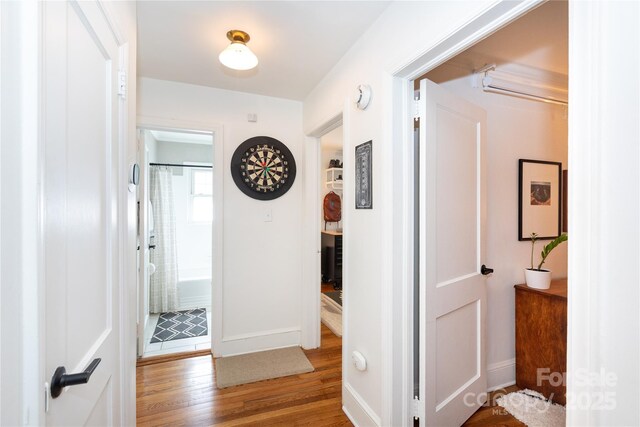 hall featuring wood finished floors and baseboards