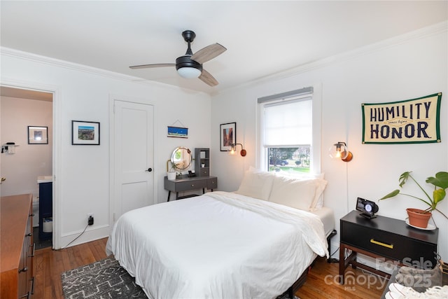 bedroom with dark wood finished floors, baseboards, a ceiling fan, ensuite bath, and crown molding