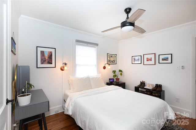 bedroom featuring dark wood finished floors, crown molding, and baseboards