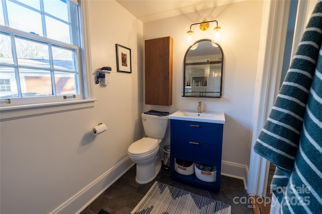 bathroom featuring toilet, tile patterned flooring, baseboards, and vanity