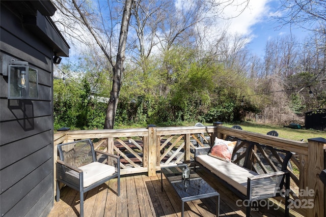 wooden terrace featuring a lawn