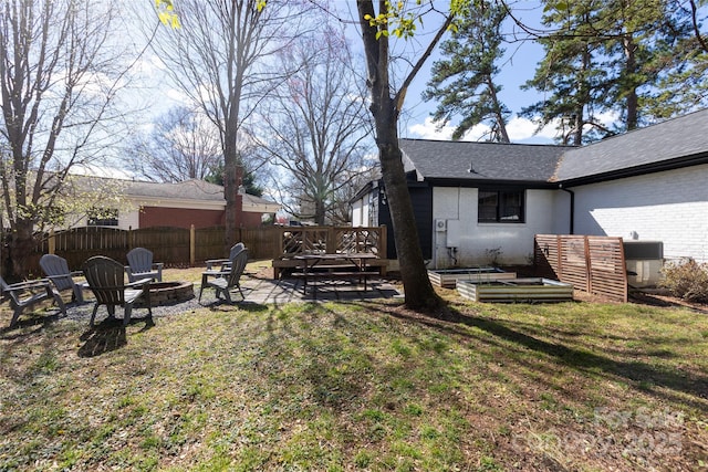 view of yard featuring a patio, an outdoor fire pit, central air condition unit, fence, and a vegetable garden