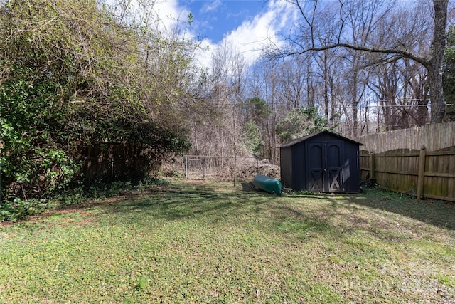 view of yard with a storage unit, an outdoor structure, and a fenced backyard