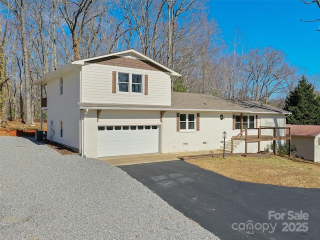 view of front of property with driveway, crawl space, an attached garage, central air condition unit, and brick siding