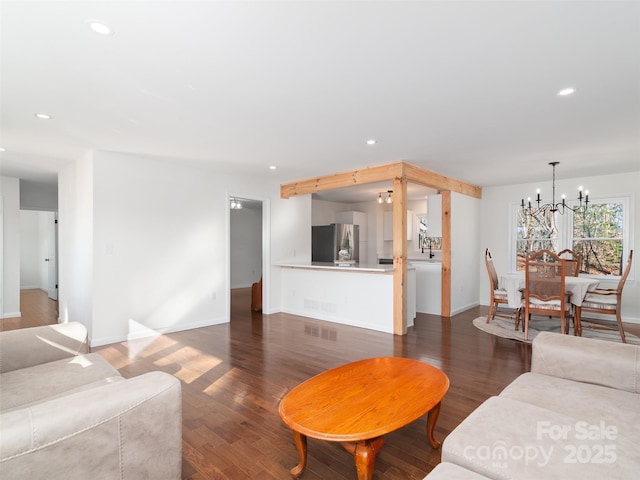 living room featuring a chandelier, recessed lighting, and dark wood finished floors