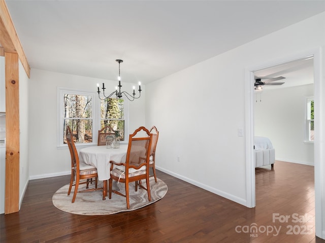 dining area featuring dark wood-type flooring, baseboards, and ceiling fan with notable chandelier