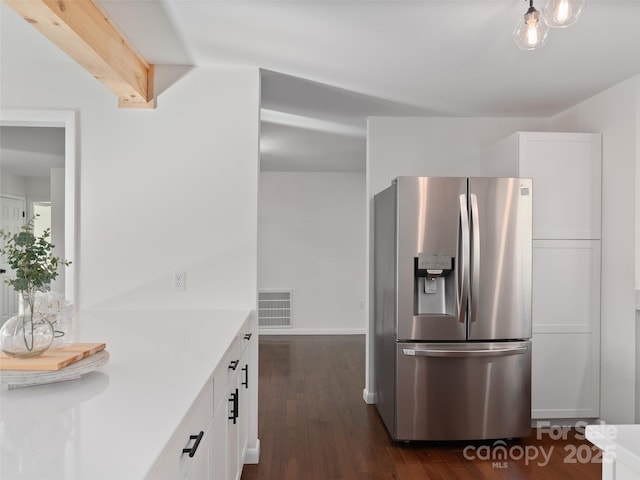 kitchen with visible vents, white cabinets, light countertops, stainless steel fridge, and dark wood finished floors