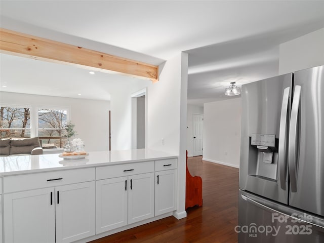 kitchen featuring open floor plan, light countertops, stainless steel refrigerator with ice dispenser, beam ceiling, and dark wood finished floors