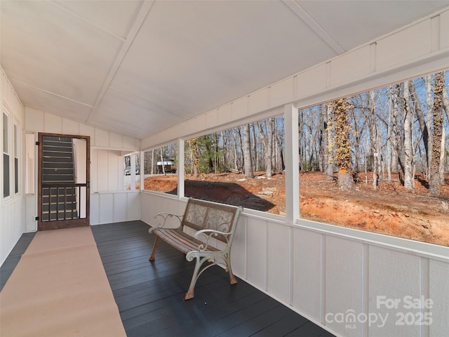 sunroom / solarium featuring vaulted ceiling