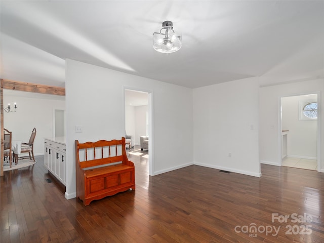 bedroom featuring dark wood-style floors, baseboards, visible vents, and a notable chandelier