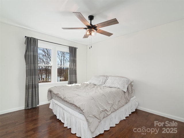 bedroom featuring a ceiling fan, baseboards, and wood finished floors