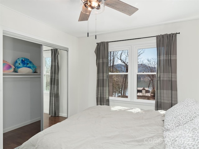 bedroom featuring ceiling fan, dark wood-style flooring, and baseboards