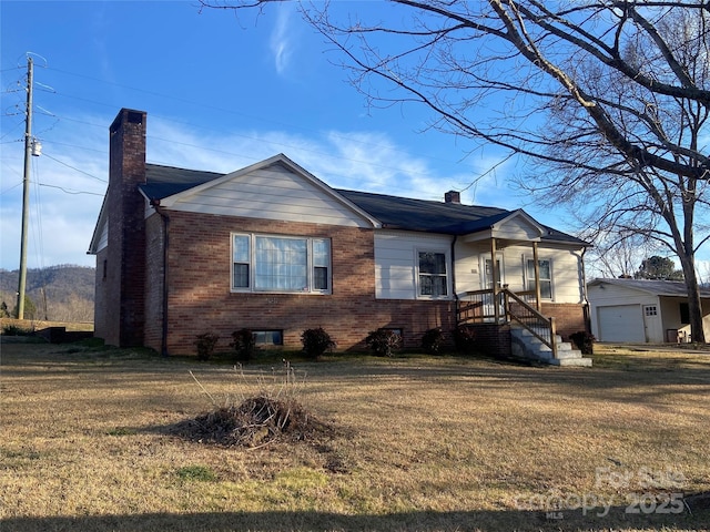 view of front of house featuring an outbuilding, brick siding, and a chimney