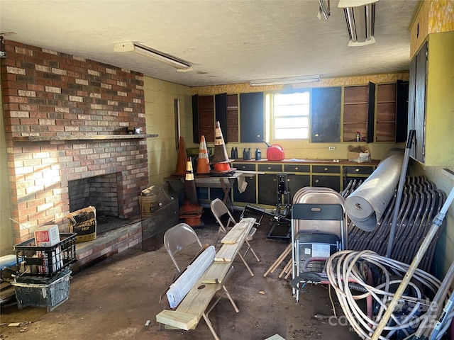 misc room featuring concrete flooring, a textured ceiling, a fireplace, and concrete block wall