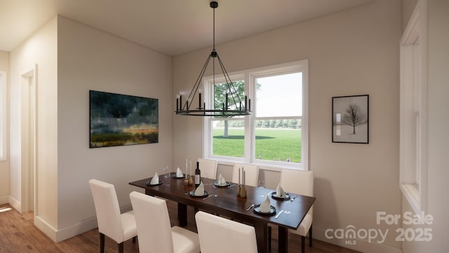 dining area with baseboards, wood finished floors, and a notable chandelier