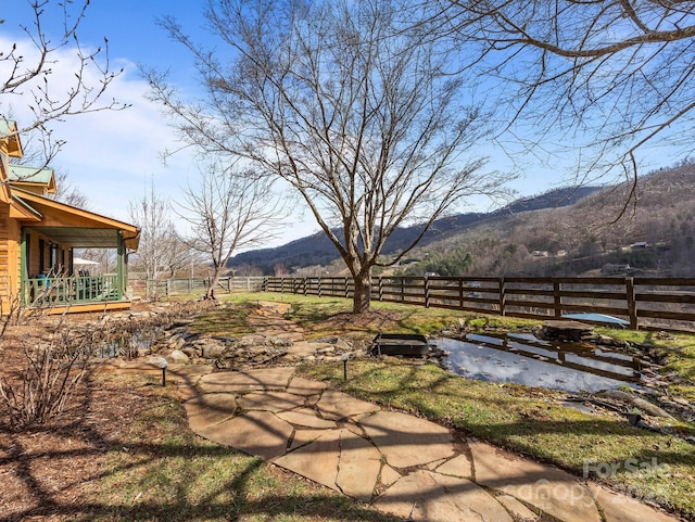 view of yard with fence and a mountain view