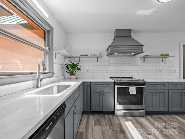 kitchen with open shelves, plenty of natural light, custom exhaust hood, and appliances with stainless steel finishes