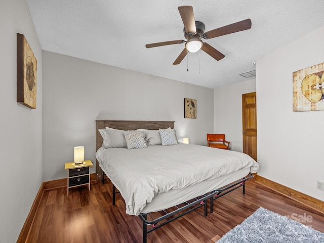 bedroom featuring ceiling fan, a textured ceiling, baseboards, and wood finished floors