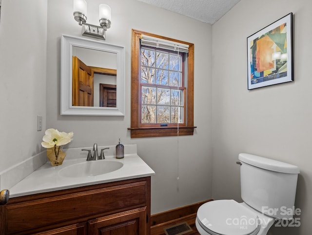 bathroom with visible vents, a textured ceiling, toilet, and vanity