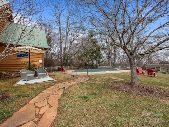 view of yard with a patio area, fence, and a fenced in pool