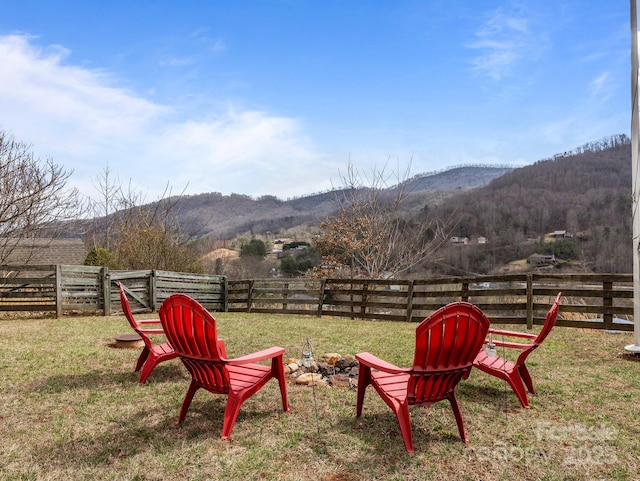 view of yard featuring a rural view, a mountain view, and fence