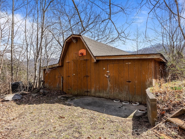 view of side of property with an outbuilding, a gambrel roof, a shingled roof, and a barn