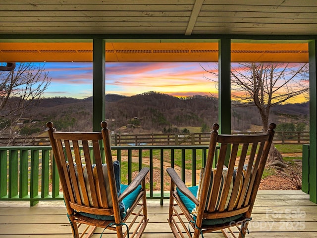 deck at dusk featuring a mountain view