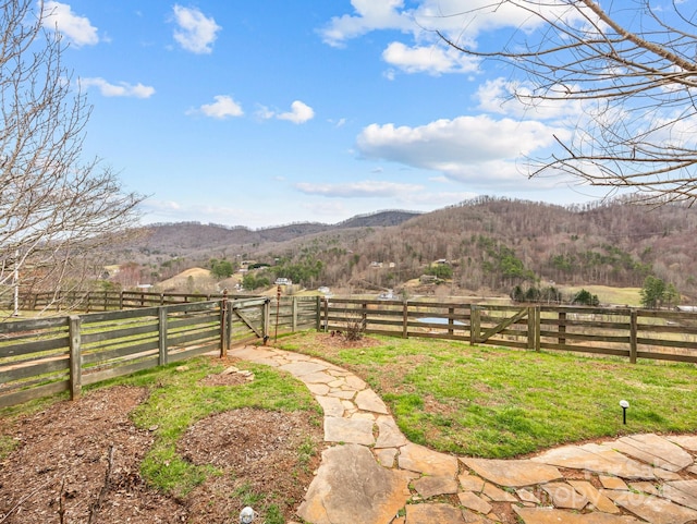 view of yard featuring a rural view, a mountain view, fence, and a gate